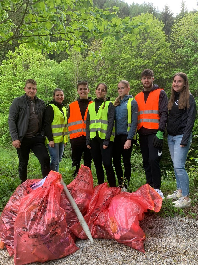 Jugendliche mit Müllsäcken in der Natur 